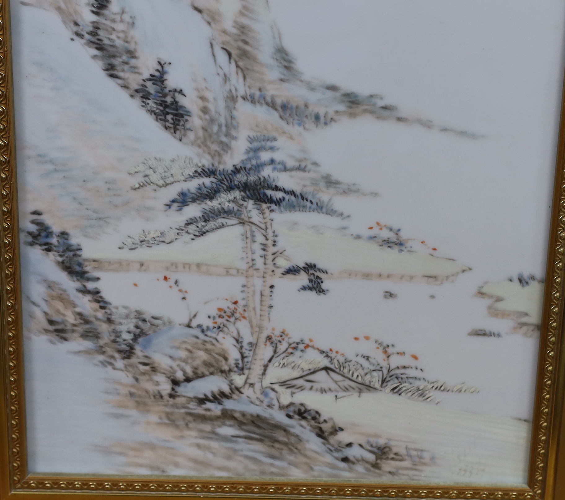 A Chinese enamelled porcelain plaque, decorated with a mountainous landscape and calligraphy, framed, overall 47cm x 34cm